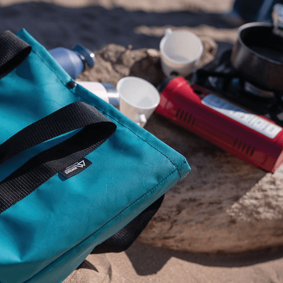 Teal Montrose bag close-up on sandy coast