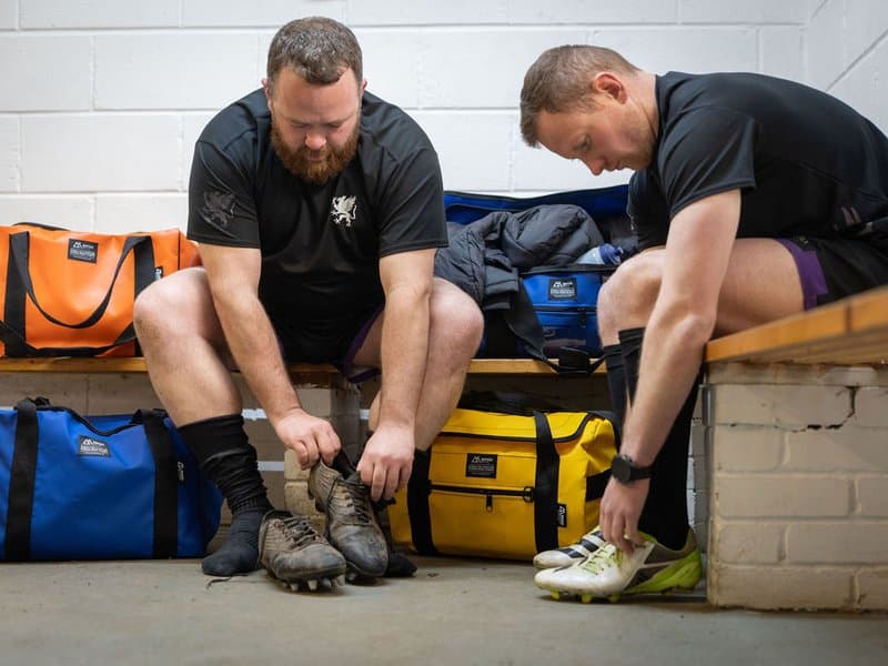Rugby players in changing room with Montrose kitbags