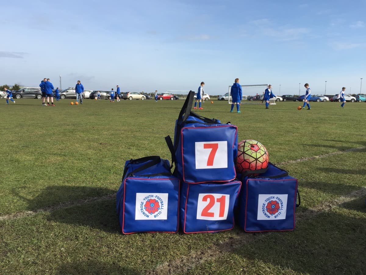 Branded football club kit bags with printed logos and squad numbers